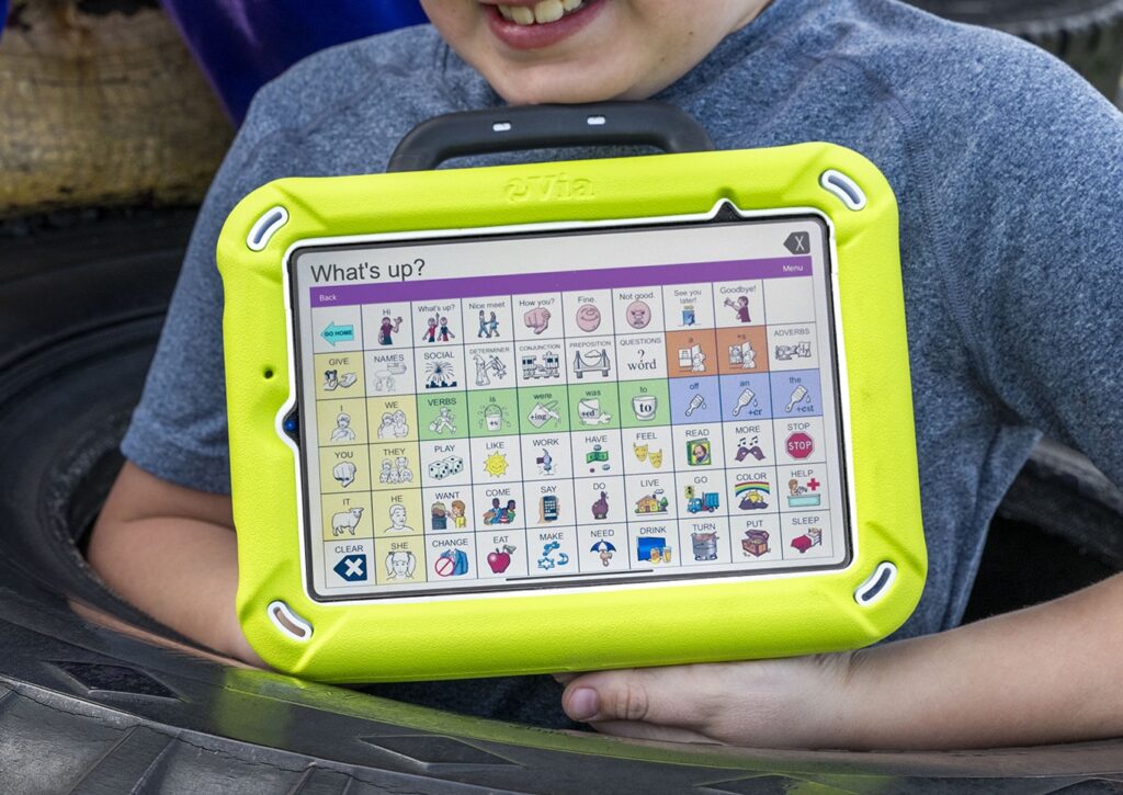 Young boy holds Via Mini AAC Device with Unity App software
