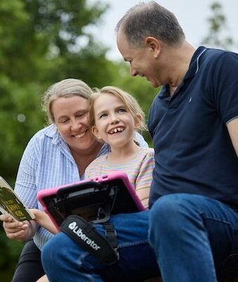 AAC Device being used by a girl and her family
